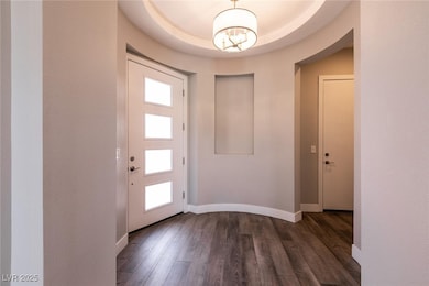 Foyer entrance with dark wood-type flooring, baseb