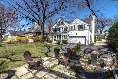 Rear view of home shows stone patio and large driv