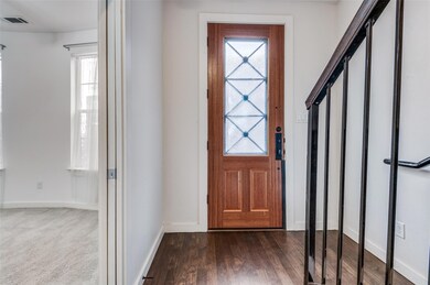 Foyer entrance with baseboards, visible vents, and