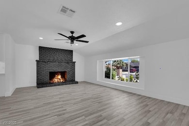 Unfurnished living room with a brick fireplace, wo