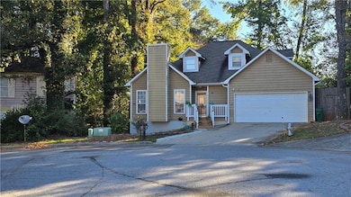 View of front of property featuring concrete driveway and a chimney