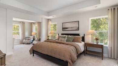 Bedroom with multiple windows, light colored carpe
