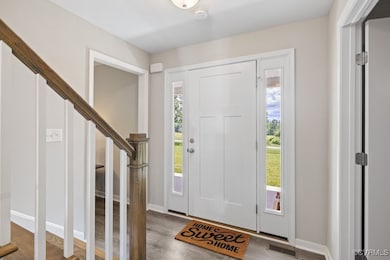 Foyer featuring wood finished floors, stairway, an