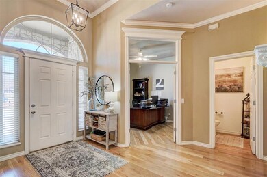 Foyer featuring plenty of natural light, wood finished floors, baseboards, and ornamental molding