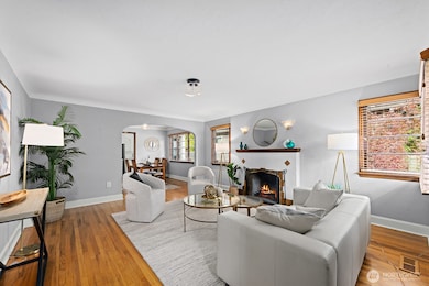 Spacious living room anchored by a stylish tiled fireplace and gleaming hardwood floors. Neutral tones and classic details create an inviting space for relaxing or entertaining.