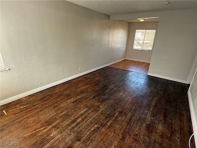 Empty room with wood-type flooring, baseboards, an