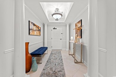 Foyer entrance with a tray ceiling, decorative col