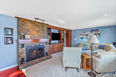 Living area featuring a fireplace and wood finished floors and built in cabinetry