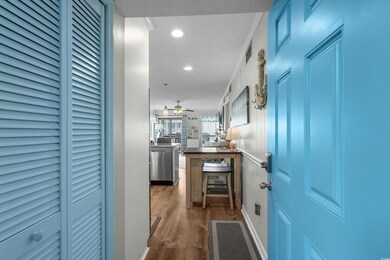 Hallway featuring wood finished floors, recessed l