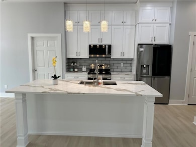 Kitchen featuring a sink, backsplash, appliances w
