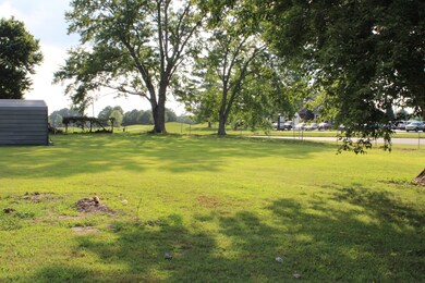 Partially fenced large backyard with a storage shed / workshop with electricity