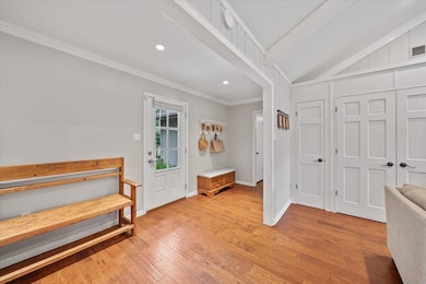 Entrance foyer featuring crown molding, light wood-type flooring, recessed lighting, lofted ceiling, and baseboards
