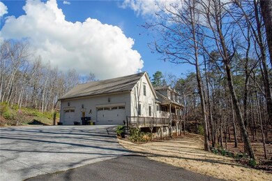 View of side of home featuring driveway, a wooden 