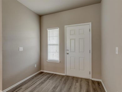 Foyer with baseboards and wood finished floors
