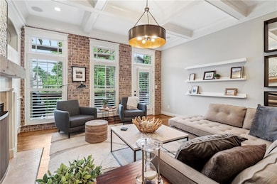 Living area with coffered ceiling, wood finished floors, a fireplace, beam ceiling, and recessed lighting