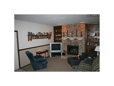 Family room with brick fireplace is located off th