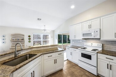 Kitchen features shaker cabinets and granite count