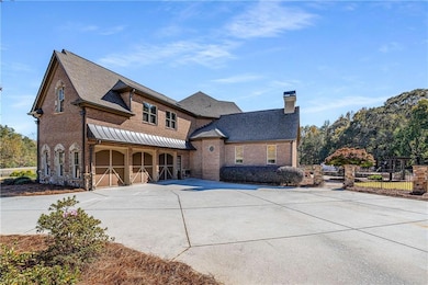 View of side facade featuring driveway, brick siding, a 3-garage, a chimney, and a shingled roof