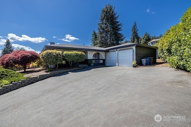 Mature landscaped yard with ornamental brush and trees adorn this large property.