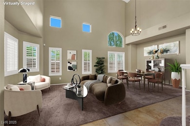 Carpeted living area featuring a chandelier and a