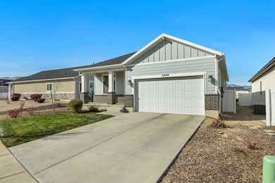Craftsman house with brick siding, covered porch, driveway, board and batten siding, and a garage