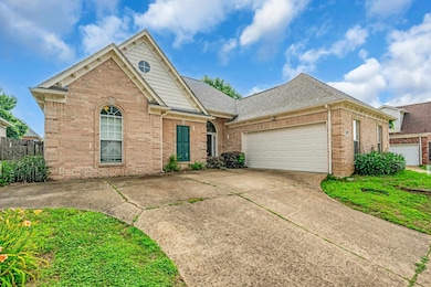 View of front of property with brick siding, driveway, an attached garage, and a shingled roof
