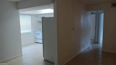 Corridor with baseboards and light tile patterned flooring
