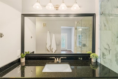 Bathroom featuring a marble finish shower and van