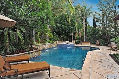 Large pool and spa surrounded by lush landscape in