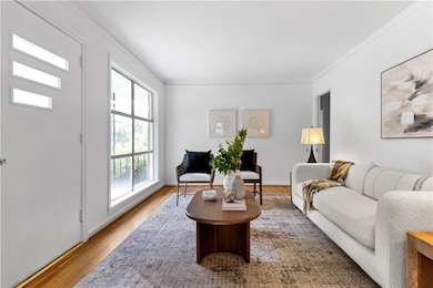Living room with crown molding and wood finished floors