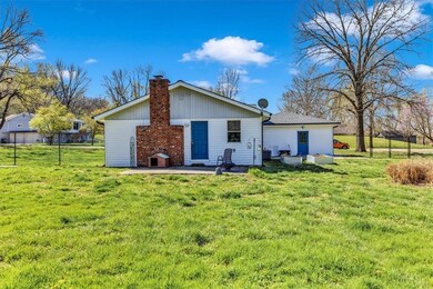 Back of property with a lawn and a patio