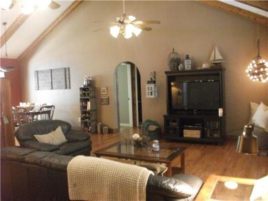 View of your entry into large, yet cozy great room with hardwood floors and exposed beams.