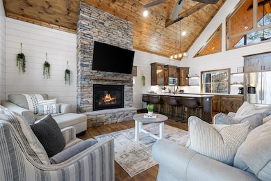 Living room featuring beam ceiling, high vaulted c