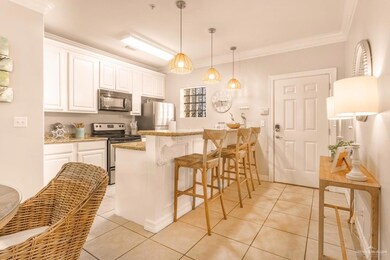 Kitchen featuring light tile patterned floors, a peninsula, stainless steel appliances, white cabinets, and a kitchen bar