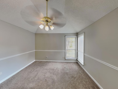 Unfurnished room with a textured ceiling, carpet flooring, and ceiling fan