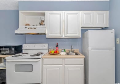 Kitchen featuring white cabinets, white appliances