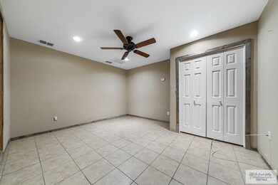 Unfurnished bedroom with a closet, ceiling fan, and light tile patterned floors
