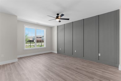 Empty room featuring light wood-style floors and a ceiling fan