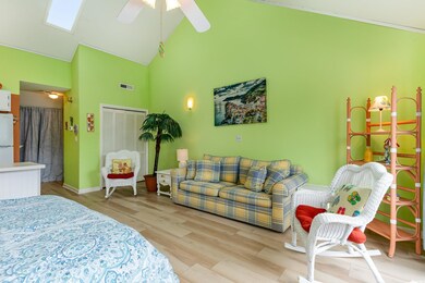 Bedroom with ceiling fan, a towering ceiling, wood