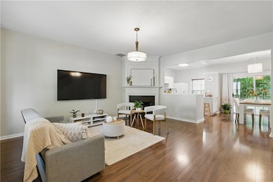 Living room with dark wood-style floors, a firepla