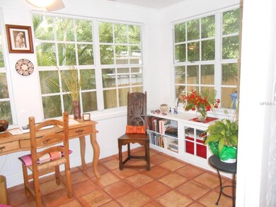 Sun room features terra cotta tile and built in book cases.