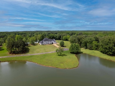 View from above of property featuring a forest and a nearby body of water