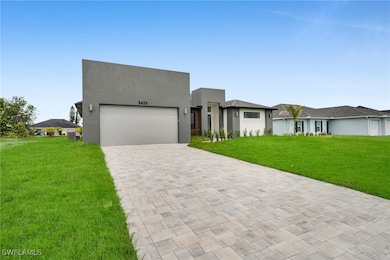 Contemporary home with decorative driveway, an att