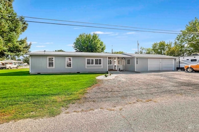 Ranch-style house with a metal roof, driveway, crawl space, a front lawn, and a garage