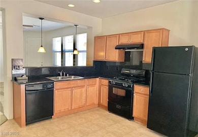 Kitchen with black appliances, a sink, under cabin