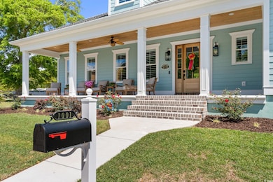 Doorway to property featuring covered porch and a lawn