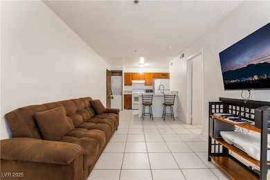 Living area with a textured ceiling, light tile pa