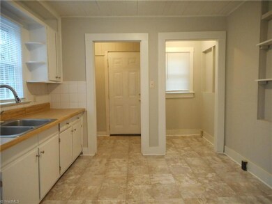 Kitchen: Room features include vinyl flooring for easy cleaning, fresh paint, two windows for natural lighting and crown molding. The open doorway on the left is the laundry room and rear entry door and you have a nice nook on the right side. Maybe you could put in some shelves and create a nice pantry area and storage closet.