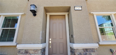 Property entrance featuring stucco siding and ston