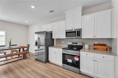 Kitchen featuring white cabinets, visible vents, d